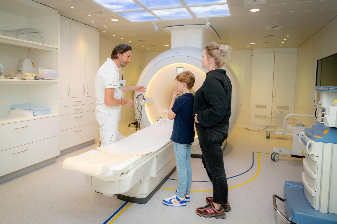 Kind met ouder in de onderzoekskamer met MRI-scanner